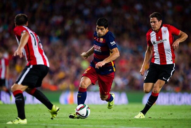 BARCELONA, SPAIN - AUGUST 17: Luis Suarez (C) of FC Barcelona runs with the ball between Carlos Gurpegi (L) and Gorka Elustondo (R) of Athletic Club during the Spanish Super Cup second leg match between FC Barcelona and Athletic Club at Camp Nou on August 17, 2015 in Barcelona, Spain. (Photo by Alex Caparros/Getty Images)
