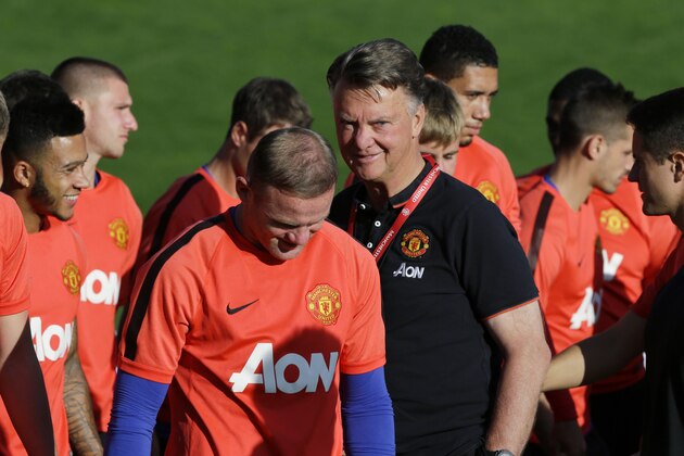 Manchester United manager Louis van Gaal, center, stands near captain Wayne Rooney, center left, after a team huddle during training Thursday, July 16, 2015, in Renton, Wash. Manchester United is in the Seattle area for an international friendly soccer match against Mexico's Club America on Friday. (AP Photo/Ted S. Warren)