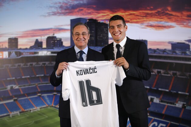 Real Madrid's new soccer player Mateo Kovacic, right, poses with club President Florentino Perez during his official presentation to the media at the Santiago Bernabeu stadium in Madrid, Spain, Wednesday, Aug. 19, 2015. Kovacic, who played before in Italian Inter Milan team, has signed a contract for six seasons. (AP Photo/Francisco Seco)