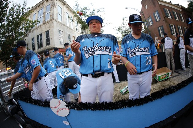 A member of the Little League team from Oregon catches a piece of candy as he and his team ride in the Little League Grand Slam Parade in downtown Williamsport, Pa., Wednesday, Aug. 19, 2015. The Little League World Series tournament gets started, Thursday, August 20, in South Williamsport, Pa.. AP Photo/Gene J. Puskar).