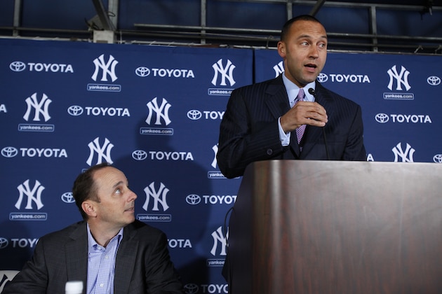 New York Yankees general manager Brian Cashman, left, looks on as shortstop Derek Jeter addresses the media during a press conference Tuesday, Dec. 7, 2010 at George M. Steinbrenner Field in Tampa, Fla. announcing the signing of Jeter's $51 million, three-year contract. (AP Photo/Brian Blanco)