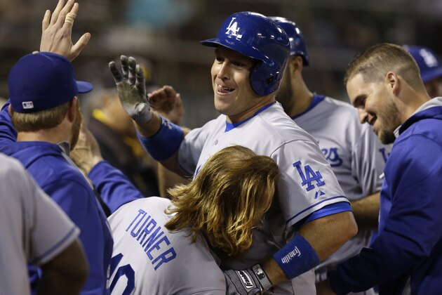 Los Angeles Dodgers' A.J. Ellis, center, celebrates with Justin Turner (10) after hitting a three-run home run off Oakland Athletics' Fernando Rodriguez in the eighth inning of a baseball game Tuesday, Aug. 18, 2015, in Oakland, Calif. (AP Photo/Ben Margot)