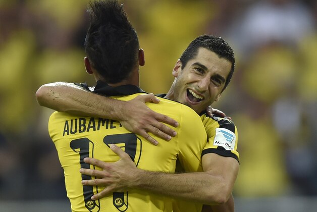 Dortmund's Henrikh Mkhitaryan, right, celebrates after scoring the third goal of the game assisted by teammate Pierre-Emerick Aubameyang, left, during the German Bundesliga soccer match between Borussia Dortmund and Borussia Moenchengladbach in Dortmund, Germany, Saturday, Aug. 15, 2015. (AP Photo/Martin Meissner)