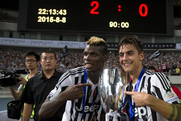 Juventus' Paulo Dybala, right and Paul Labile Pogba pose with the trophy after beating Lazio during the 2015 TIM Italian Supercup held at the Shanghai Stadium in Shanghai, China, Saturday, Aug. 8, 2015. Juventus defeat Lazio 2-0 to win the Supercup. (AP Photo/Ng Han Guan)