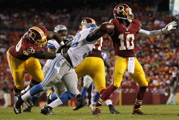 Aug 20, 2015; Landover, MD, USA; Washington Redskins quarterback Robert Griffin III (10) is hit by Detroit Lions defensive end Phillip Hunt (58) while throwing the ball in the first quarter at FedEx Field. Mandatory Credit: Geoff Burke-USA TODAY Sports