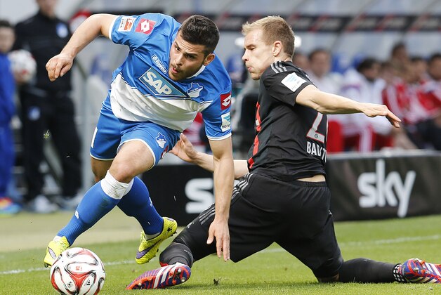 Hoffenheim's Kevin Volland, left, and Bayern's Holger Badstuber challenge for the ball during a German first division Bundesliga soccer match between TSG 1899 Hoffenheim and Bayern Munich in Sinsheim, Germany, Saturday, April 18, 2015. (AP Photo/Michael Probst)