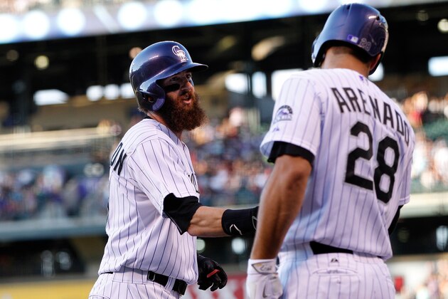 DENVER, CO - AUGUST 04:  Charlie Blackmon #19 of the Colorado Rockies celebrates his solo home run off of Vidal Nuno #38 of the Seattle Mariners with Nolan Arenado #28 of the Colorado Rockies as the Mariners held a 2-1 lead in the first inning during interleague play at Coors Field on August 4, 2015 in Denver, Colorado.  (Photo by Doug Pensinger/Getty Images)