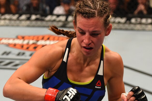 CHICAGO, IL - JULY 25:   Miesha Tate rushes in after dropping Jessica Eye with a punch in their women's bantamweight bout during the UFC event at the United Center on July 25, 2015 in Chicago, Illinois. (Photo by Jeff Bottari/Zuffa LLC/Zuffa LLC via Getty Images)