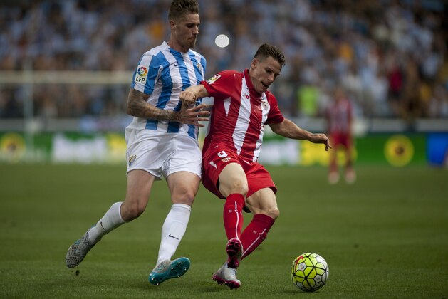 Malaga's defender Raul Albentosa (L) vies with Sevilla's French forward Kevin Gameiro during the Spanish league football match Malaga CF vs Sevilla FC at La Rosaleda stadium in Malaga on August 21, 2015.  AFP PHOTO / JORGE GUERRERO        (Photo credit should read Jorge Guerrero/AFP/Getty Images)
