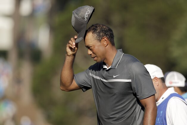 Tiger Woods tips his hat to the crowd on the 18th hole during the second round of the Wyndham Championship golf tournament in Greensboro, N.C., Friday, Aug. 21, 2015. (AP Photo/Chuck Burton)