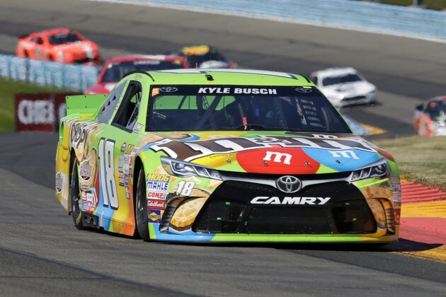 Kyle Busch (18) leads a group of racers through the esses  during a NASCAR Sprint Cup series auto race at Watkins Glen International, Sunday, Aug. 9, 2015, in Watkins Glen, N.Y. (AP Photo/Mel Evans)