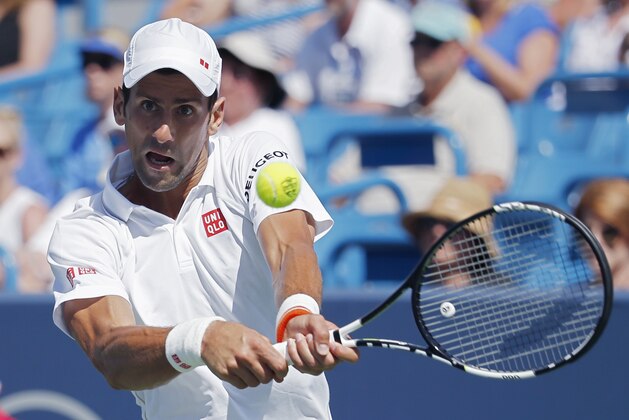 Novak Djokovic, of Serbia, returns the ball to Stanislas Wawrinka, of Switzerland, during a quarterfinal match at the Western & Southern Open tennis tournament, Friday, Aug. 21, 2015, in Mason, Ohio. (AP Photo/John Minchillo)