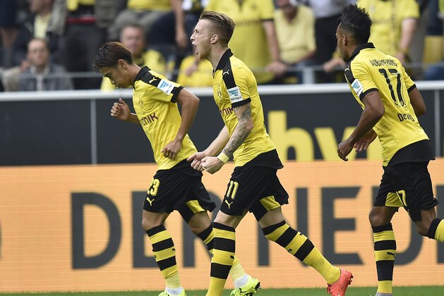 Dortmund's Marco Reus, center, celebrates after scoring the opening goal  during the German Bundesliga soccer match between Borussia Dortmund and Borussia Moenchengladbach in Dortmund, Germany, Saturday, Aug. 15, 2015. (AP Photo/Martin Meissner)