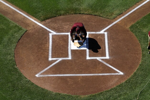 A grounds crew member prepares to paint home plate before the first baseball game in United States pool play between Portland, Ore., and Pearland, Texas at the Little League World Series tournament in South Williamsport, Pa., Friday, Aug. 21, 2015. (AP Photo/Gene J. Puskar)