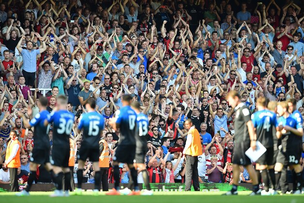 Bouremouth supporters applaud their team after the English Premier League football match between West Ham United and Bournemouth at The Boleyn Ground in Upton Park, East London on August 22, 2015. Bournemouth won the game 4-3. AFP PHOTO / BEN STANSALL

RESTRICTED TO EDITORIAL USE. No use with unauthorized audio, video, data, fixture lists, club/league logos or 'live' services. Online in-match use limited to 75 images, no video emulation. No use in betting, games or single club/league/player publications.        (Photo credit should read BEN STANSALL/AFP/Getty Images)