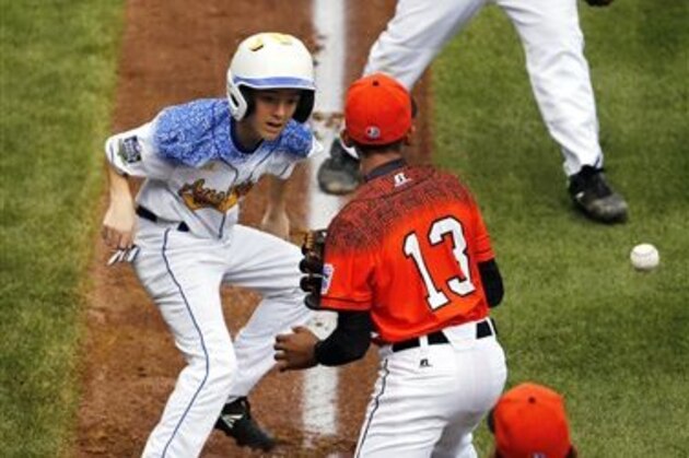 The ball gets away from Dominican Republic's Emmanuel Rodriguez (13) during a run down between third and home of Australia's Mark Natta, left, during the first inning of an International elimination baseball game at the Little League World Series tournament in South Williamsport, Pa., Saturday, Aug. 22, 2015. Natta retreated to third safely on the error. Australia won 3-0.  (AP Photo/Gene J. Puskar)
