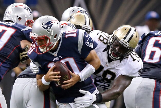 Aug 22, 2015; New Orleans, LA, USA; New England Patriots quarterback Jimmy Garoppolo (10) is grabbed, but not sacked, by New Orleans Saints defensive tackle Bobby Richardson (78) in the second quarter at Mercedes-Benz Superdome. Mandatory Credit: Chuck Cook-USA TODAY Sports