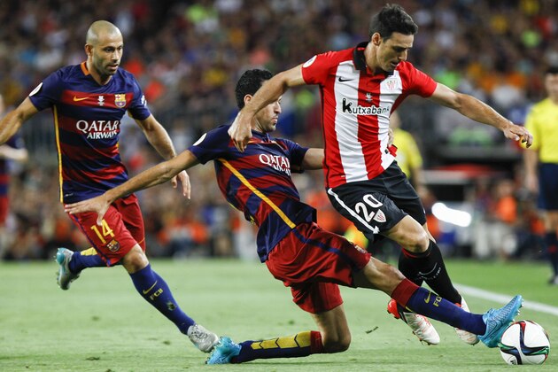 Barcelona's midfielder Sergio Busquets (C) vies with Athletic Bilbao's forward Aritz Aduriz (R) during the Spanish Supercup second-leg football match FC Barcelona vs Athletic Club Bilbao at the Camp Nou stadium in Barcelona on August 17, 2015. AFP PHOTO / QUIQUE GARCIA        (Photo credit should read QUIQUE GARCIA/AFP/Getty Images)
