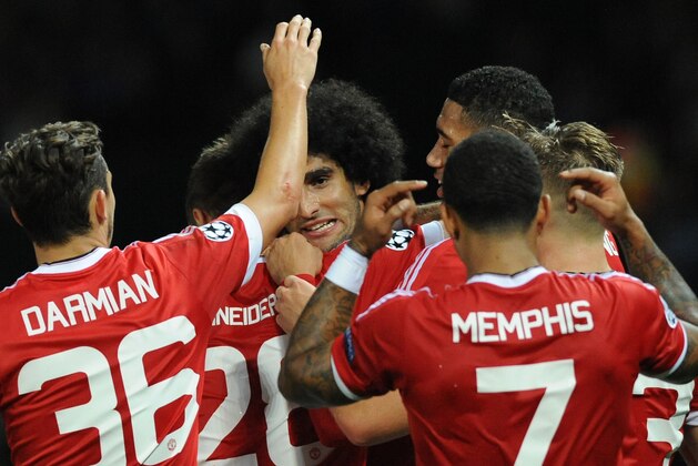 Manchester United’s Marouane Fellaini, middle, is congratulated after scoring against Brugge during the Champions League play-off round, first leg soccer match between Manchester United and Club Brugge at Old Trafford, Manchester, England, Tuesday, Aug. 18, 2015. (AP Photo/Rui Vieira)