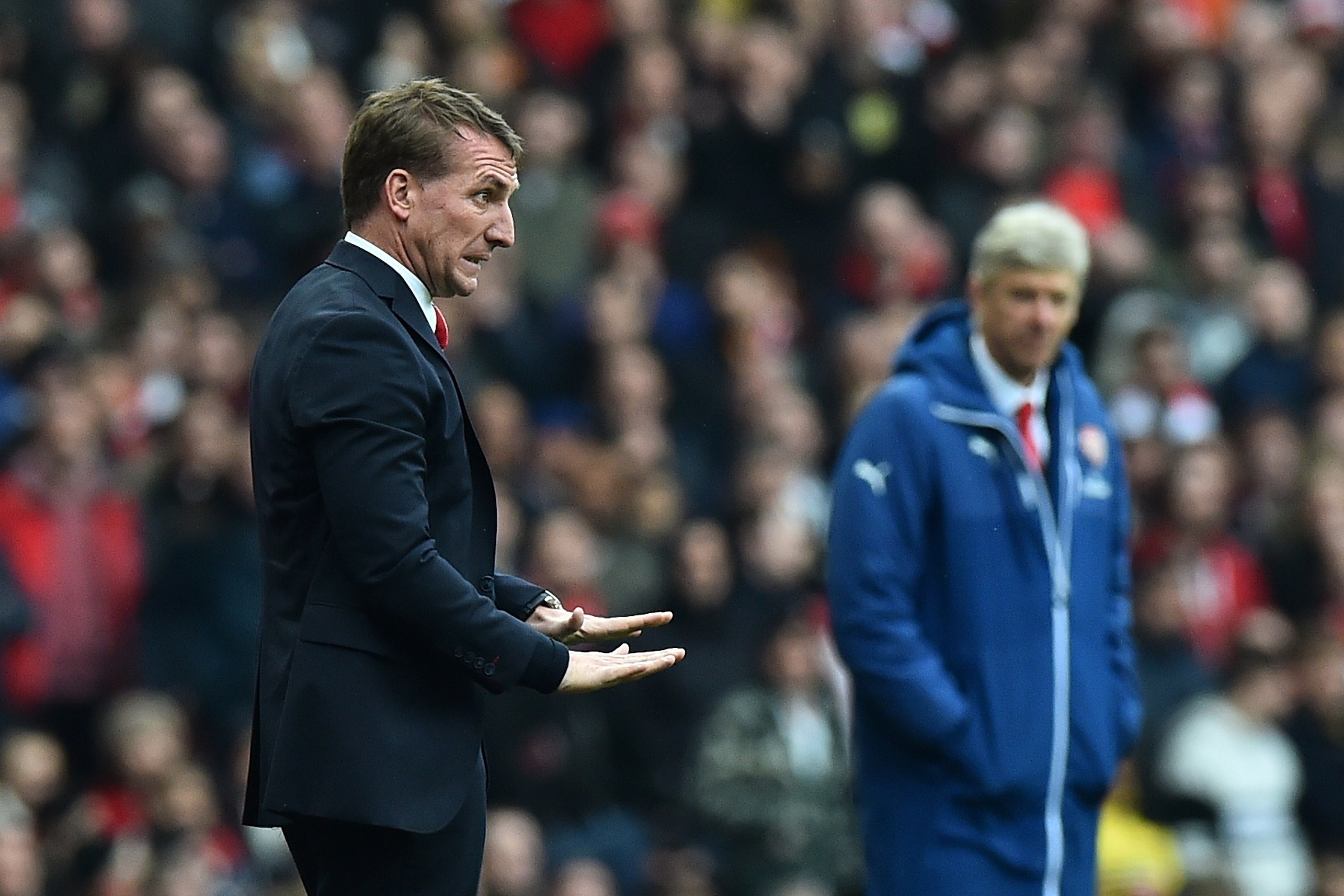 Liverpool's Northern Irish manager  Brendan Rodgers (L) gestures as Arsenal's French manager Arsene Wenger looks on during the English Premier League football match between Arsenal and Liverpool at the Emirates Stadium in London on April 4, 2015. AFP PHOTO / BEN STANSALL

RESTRICTED TO EDITORIAL USE. NO USE WITH UNAUTHORIZED AUDIO, VIDEO, DATA, FIXTURE LISTS, CLUB/LEAGUE LOGOS OR LIVE SERVICES. ONLINE IN-MATCH USE LIMITED TO 45 IMAGES, NO VIDEO EMULATION. NO USE IN BETTING, GAMES OR SINGLE CLUB/LEAGUE/PLAYER PUBLICATIONS.        (Photo credit should read BEN STANSALL/AFP/Getty Images)