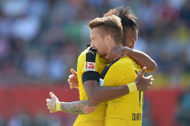Dortmund's Gabonese striker Pierre-Emerick Aubameyang (L) and his teammate Dortmund's midfielder Marca Reus (R) celebrate after the penalty kick goal for Dortmund during the German first division Bundesliga football match FC Ingolstadt 04 vs Borussia Dortmund, on August 23, 2015 in Ingolstadt.  AFP PHOTO / CHRISTOF STACHE

RESTRICTIONS: DURING MATCH TIME: DFL RULES TO LIMIT THE ONLINE USAGE TO 15 PICTURES PER MATCH AND FORBID IMAGE SEQUENCES TO SIMULATE VIDEO. 
== RESTRICTED TO EDITORIAL USE == FOR FURTHER QUERIES PLEASE CONTACT DFL DIRECTLY AT + 49 69 650050.        (Photo credit should read CHRISTOF STACHE/AFP/Getty Images)