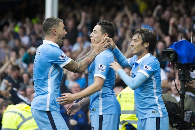 Manchester City's Samir Nasri, center, celebrates with teammate and fellow goal scorer Aleksandar Kolarov, left, as David Silva looks on after scoring against during the English Premier League soccer match between Everton and Manchester City at Goodison Park Stadium, Liverpool, England, Sunday Aug. 23, 2015. (AP Photo/Jon Super)