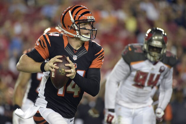 Cincinnati Bengals quarterback Andy Dalton (14) scrambles away rom Tampa Bay Buccaneers defensive end George Johnson (94) during the first quarter of an NFL preseason football game Monday, Aug. 24, 2015, in Tampa, Fla. (AP Photo/Phelan M. Ebenhack)