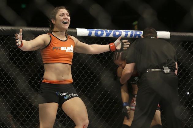 Bethe Correia, left, celebrates after defeating Shayna Baszler, rear, who is tended to by referee John McCarthy after a women's bantamweight mixed martial arts bout at UFC 177 in Sacramento, Calif., Saturday, Aug. 30, 2014. Correia won in the second round. (AP Photo/Jeff Chiu)