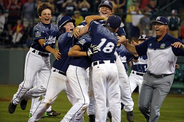 Lewisberry, Pennsylvania's Jaden Henline is mobbed by teammates and coaches after hitting a walk-off two-run double in the sixth inning of a baseball game in United States pool play against Taylors, South Carolina at the Little League World Series tournament in South Williamsport, Pa., Sunday, Aug. 23, 2015. Lewisberry, Pennsylvania won 9-8. (AP Photo/Gene J. Puskar)