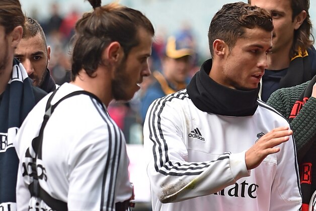 Real Madrid players Cristiano Ronaldo (C) Gareth Bale (L) and Marcelo de Silva (R) hold Australian Rules footballs after a team training session ahead of the International Champions Cup football tournament in Melbourne on July 17, 2015.   AFP PHOTO / PAUL CROCK-- IMAGE RESTRICTED TO EDITORIAL USE - STRICTLY NO COMMERCIAL USE        (Photo credit should read PAUL CROCK/AFP/Getty Images)
