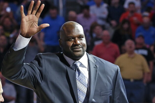 Former NBA basketball player Shaquille O'Neal waves to fans as he is honored  during an NBA basketball game between the Orlando Magic and the Detroit Pistons after he was inducted in the Magic Hall of Fame, Friday, March 27, 2015, in Orlando, Fla. Selected by Orlando with the first overall pick of the 1992 NBA Draft, O'Neal spent four seasons with the Magic from 1992-96. (AP Photo/John Raoux)