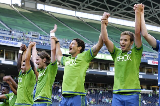 Seattle Sounders players Thomas, right, Nelson Valdez, second from right, and Erik Friberg, third from right, celebrate after they defeated Orlando City 4-0 in an MLS soccer match, Sunday, Aug. 16, 2015, in Seattle. (AP Photo/Ted S. Warren)