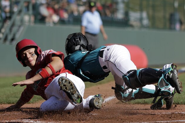 Mexico's Armando Verdugo, left, collides with Venezuela's Adrian Sandoval to score on a two-run double by Daniel Zaragoza during the second inning of an International elimination baseball game at the Little League World Series tournament, Thursday, Aug. 27, 2015, in South Williamsport, Pa. (AP Photo/Matt Slocum)