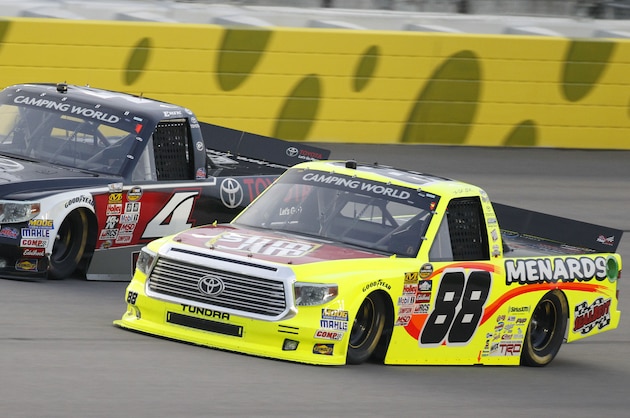 NASCAR drivers Erik Jones (4) and Matt Crafton (88) race side-by-side during a Truck Series auto race at Kansas Speedway in Kansas City, Kan., Friday, May 8, 2015. (AP Photo/Colin E. Braley)