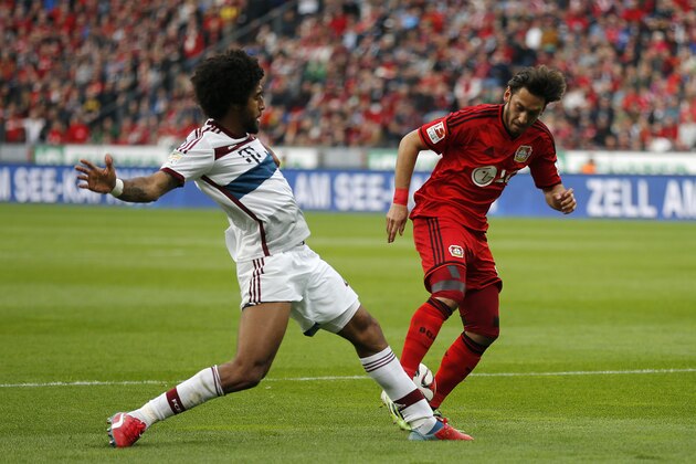 Bayern's Dante from Brazil, left, and Leverkusen's Hakan Calhanoglu from Turkey challenge for the ball during the German first division Bundesliga soccer match between Bayer 04 Leverkusen and Bayern Munich in Leverkusen, Germany, Saturday, May 2, 2015. (AP Photo/Frank Augstein)
