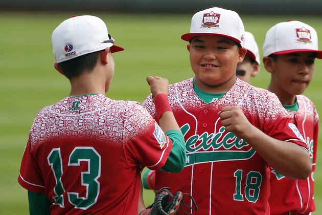 Mexico's Daniel Zaragoza (18) celebrates with Alberto Bustos (13) after an International elimination baseball game against Venezuela at the Little League World Series tournament in South Williamsport, Pa., Thursday, Aug. 27, 2015. Zaragoza pitched Mexico to an 11-0 win. (AP Photo/Gene J. Puskar)