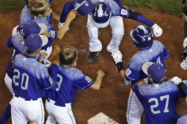 Pearland, Texas' Caleb Low (10) leaps onto home plate to begin a walk-off celebration with teammates after hitting a two-run home run off Bonita, Calif.'s Jacob Baptista during the eighth inning of a U.S. elimination baseball game at the Little League World Series in South Williamsport, Pa., Thursday, Aug. 27, 2015. Pearland won 9-7. (AP Photo/Gene J. Puskar)