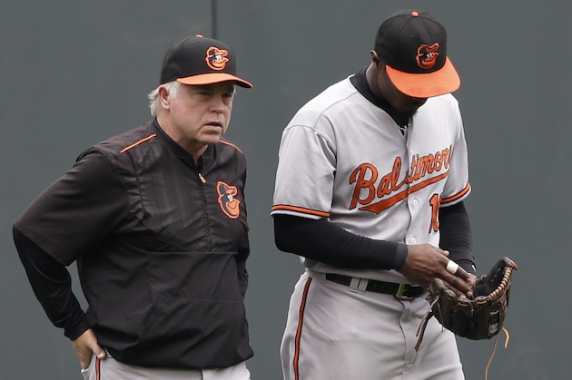 Baltimore Orioles manager Buck Showalter, left, walks center fielder Adam Jones (10) to his position after Jones was injured in the first inning of a baseball game against the Kansas City Royals at Kauffman Stadium in Kansas City, Mo., Thursday, Aug. 27, 2015. (AP Photo/Orlin Wagner)