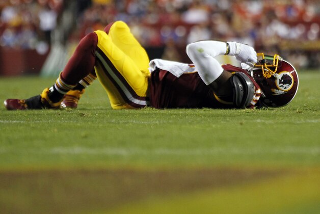 Aug 20, 2015; Landover, MD, USA; Washington Redskins quarterback Robert Griffin III (10) lies on the ground after being hit against the Detroit Lions in the first quarter at FedEx Field. Mandatory Credit: Geoff Burke-USA TODAY Sports