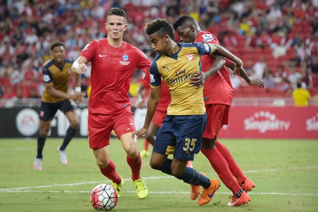 Arsenal midfielder Gedion Zelalem, center, is challenged by Singapore Selection's Sirina Camara, right, in the Barclays Asia Trophy soccer match in Singapore, Wednesday, July 15, 2015. (AP Photo/Joseph Nair)