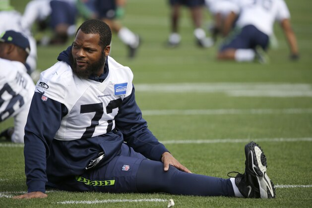 Seattle Seahawks defensive end Michael Bennett stretches Thursday, Aug. 13, 2015, during NFL football training camp in Renton, Wash. (AP Photo/Ted S. Warren)