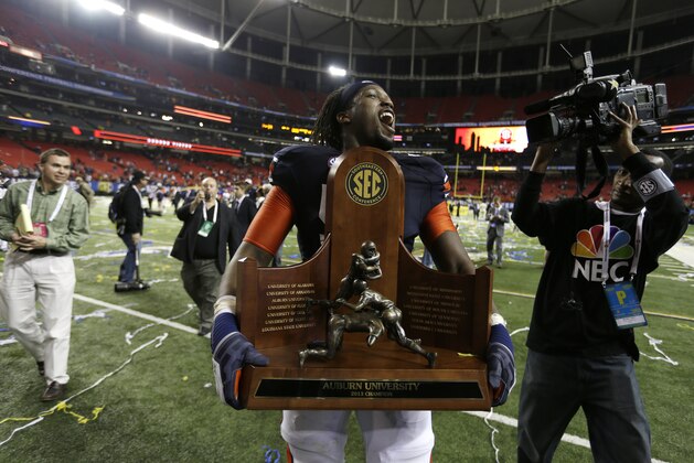 Auburn offensive linesman Avery Young (56) carries the championship trophy after the second half of the Southeastern Conference NCAA football championship game against Missouri, Saturday, Dec. 7, 2013, in Atlanta. Auburn won 59-42. (AP Photo/David Goldman)