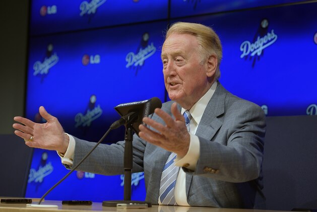Los Angeles Dodgers announcer Vin Scully speaks to the media prior to a baseball game against the Atlanta Braves, Wednesday, July 30, 2014, in Los Angeles. The 86-year-old Hall of Fame announcer said Tuesday that he will return for his record 66th season with the team in 2015. (AP Photo/Mark J. Terrill)