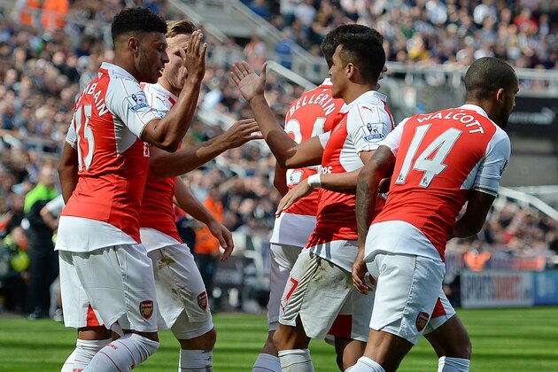 Arsenal's English midfielder Alex Oxlade-Chamberlain is congratulated by teammates after his shot deflects off Newcastle United's Argentinian defender Fabricio Coloccini (not pictured) for Arsenal's opening goal in the English Premier League football match between Newcastle United and Arsenal at St James' Park in Newcastle-upon-Tyne, north east England, on August 29, 2015. AFP PHOTO / OLI SCARFF

RESTRICTED TO EDITORIAL USE. No use with unauthorized audio, video, data, fixture lists, club/league logos or 'live' services. Online in-match use limited to 75 images, no video emulation. No use in betting, games or single club/league/player publications.        (Photo credit should read OLI SCARFF/AFP/Getty Images)