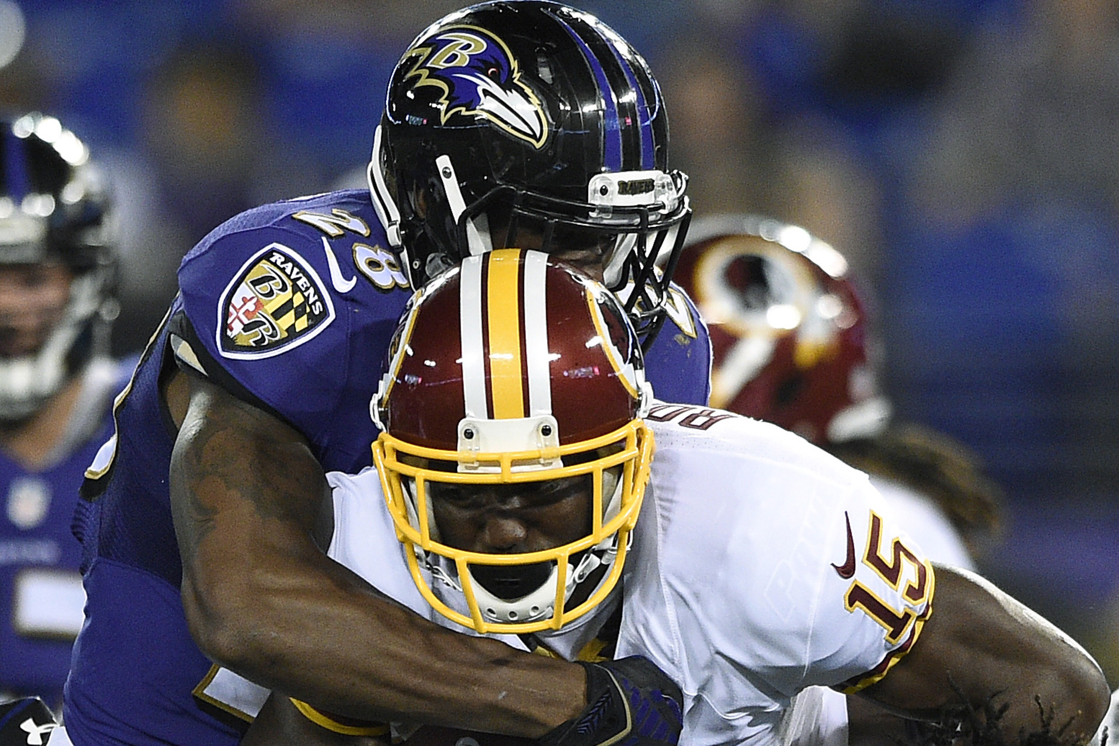 Washington Redskins wide receiver Aldrick Robinson, center, is tackled by Baltimore Ravens defenders Brynden Trawick, top, and LaQuan Williams in the second half of an NFL preseason football game, Saturday, Aug. 23, 2014, in Baltimore. (AP Photo/Nick Wass)