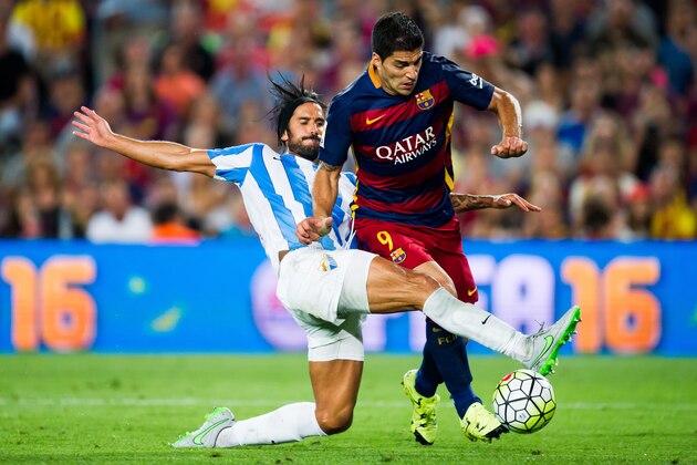 BARCELONA, SPAIN - AUGUST 29:  Luis Suarez of FC Barcelona is brought down by Marcos Angeleri of Malaga CF during the La Liga match between FC Barcelona and Malaga CF at Camp Nou on August 29, 2015 in Barcelona, Spain.  (Photo by Alex Caparros/Getty Images)