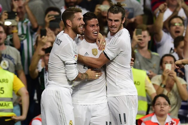 Real Madrid's Colombian midfielder James Rodriguez (C) celebrates with Real Madrid's defender Sergio Ramos (L) and Real Madrid's Welsh forward Gareth Bale (R) after scoring during the Spanish league football match Real Madrid CF vs Real Betis Balompie at the Santiago Bernabeu stadium in Madrid on August 29, 2015.   AFP PHOTO/ PIERRE-PHILIPPE MARCOU        (Photo credit should read PIERRE-PHILIPPE MARCOU/AFP/Getty Images)
