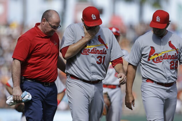 St. Louis Cardinals pitcher Lance Lynn (31) walks off the field with a trainer, left, and manager Mike Matheny, right, after injuring himself while throwing to first base in the eighth inning of a baseball game against the San Francisco Giants, Saturday, Aug. 29, 2015, in San Francisco. (AP Photo/Ben Margot)