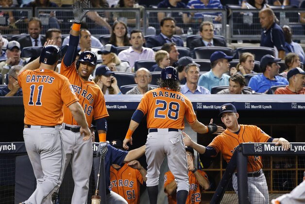 Houston Astros manager A.J. HInch, right, greets Colby Rasmus (28) as Luis Valbuena (18) celebrates with Evan Gattis (11) after Rasmus scored on Gattis's fifth-inning, two-run home run in a baseball game against the New York Yankees at Yankee Stadium in New York, Tuesday, Aug. 25, 2015. (AP Photo/Kathy Willens)