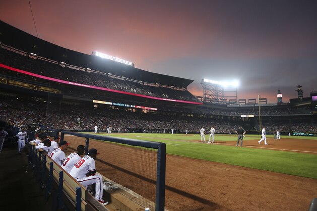 The sun sets behind Turner Field as the Atlanta Braves host the New York Yankees in a baseball game Friday, Aug. 28, 2015, in Atlanta. (AP Photo/John Bazemore)